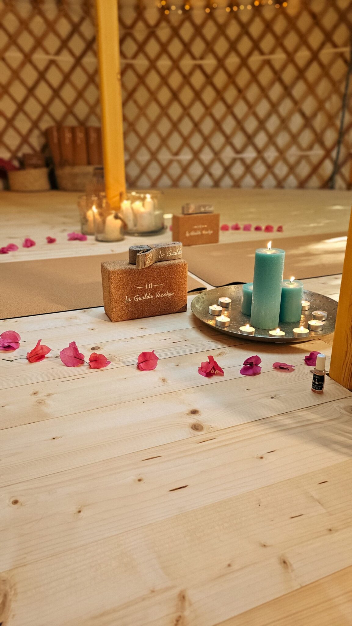 Blocchi yoga brandizzati La Gualda Vecchia con candele turchesi e petali - dettaglio wellness
